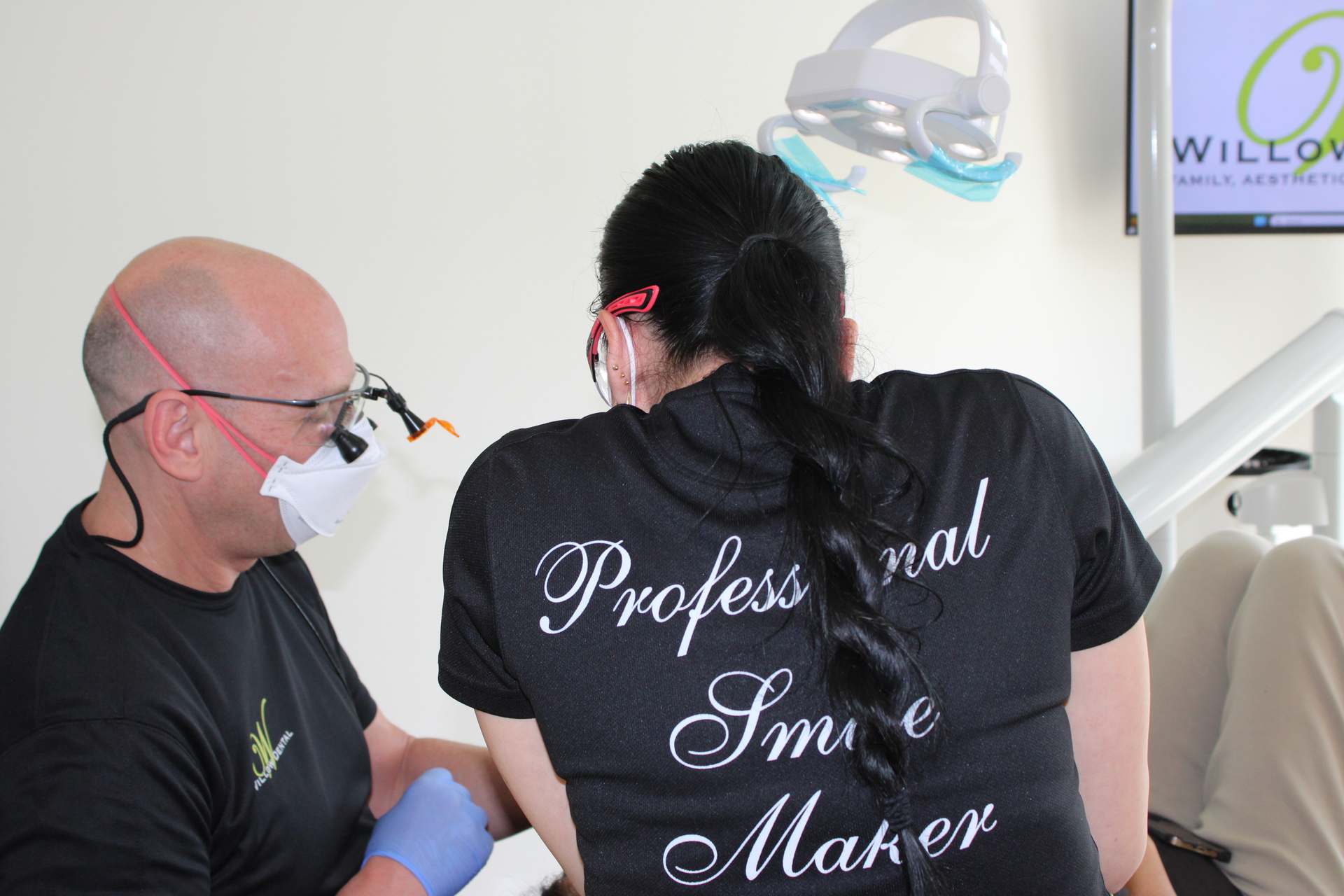 Willow Dental Associates dentist in loupes and assistant working closely, side view in Mississauga, ON