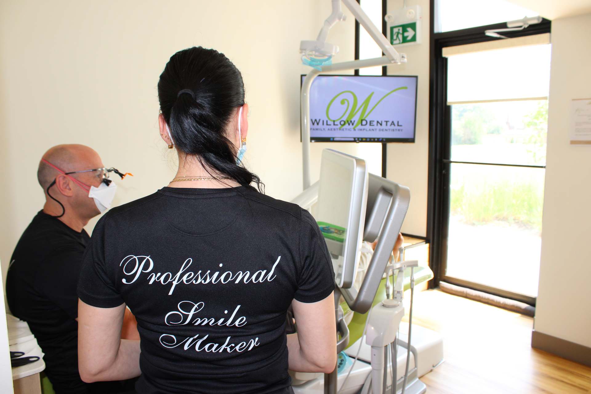 Willow Dental Associates dentist and assistant working in operatory, back view in Mississauga, ON
