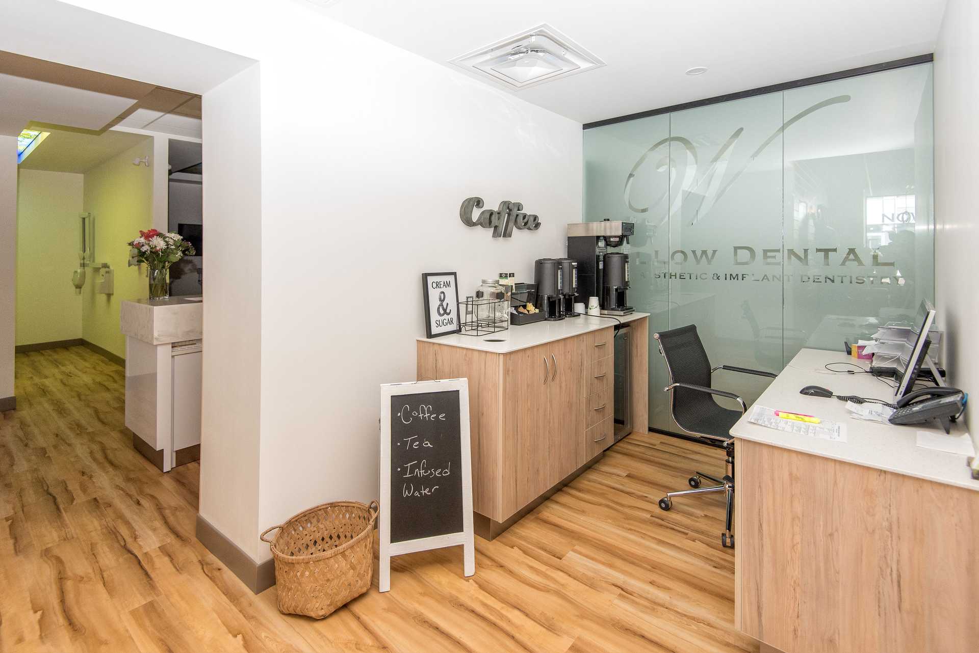 Willow Dental Associates reception desk and coffee bar with glass Willow Dental sign in Mississauga, ON