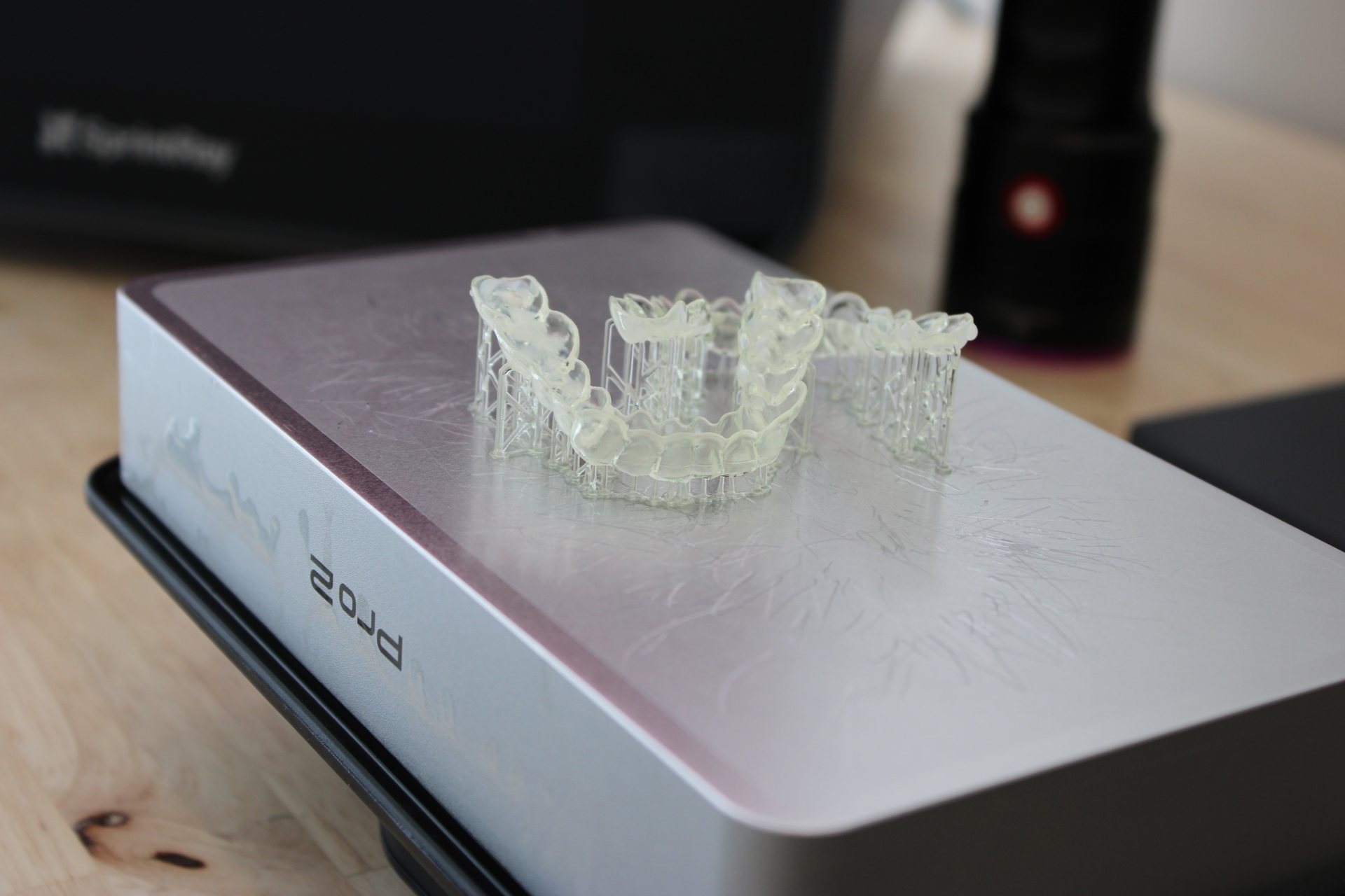 Willow Dental Associates 3D printed clear dental models on curing unit, wood counter in Mississauga, ON